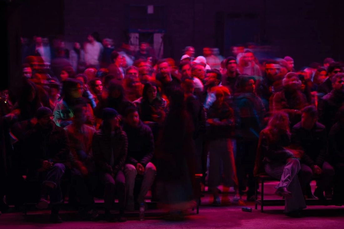 Audience under red and white light beams during a performance